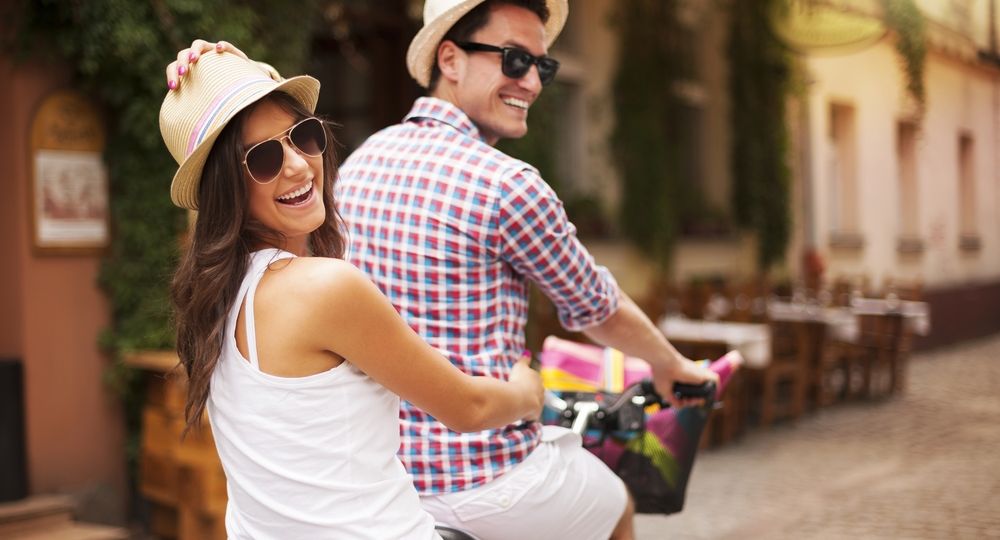 Happy couple riding a bicycle in the city street